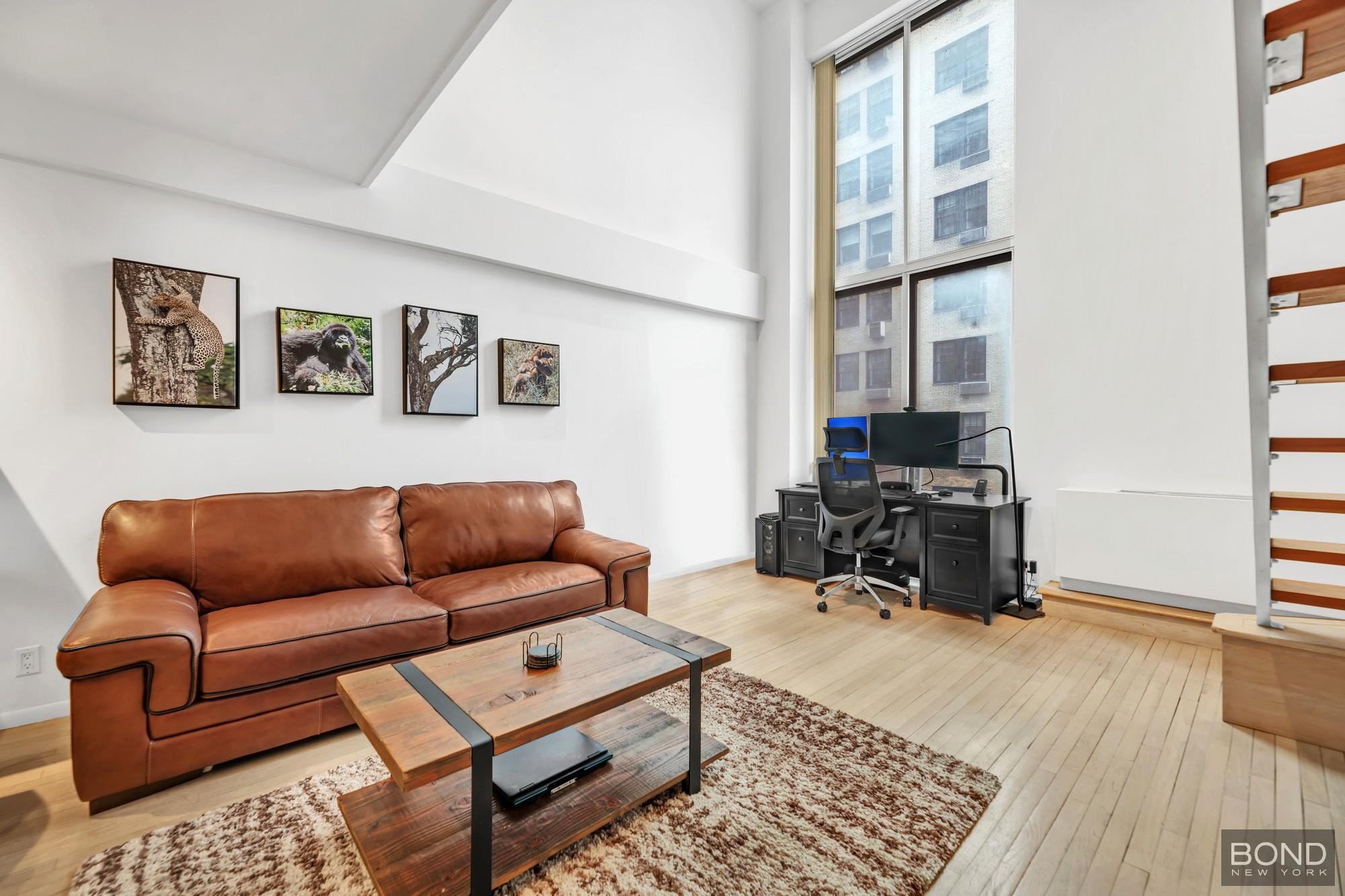 32 East 76th Street, Unit 502602 Manhattan, NY 10021 - Photo 3 of 8 a living room with furniture ceiling fan and a window