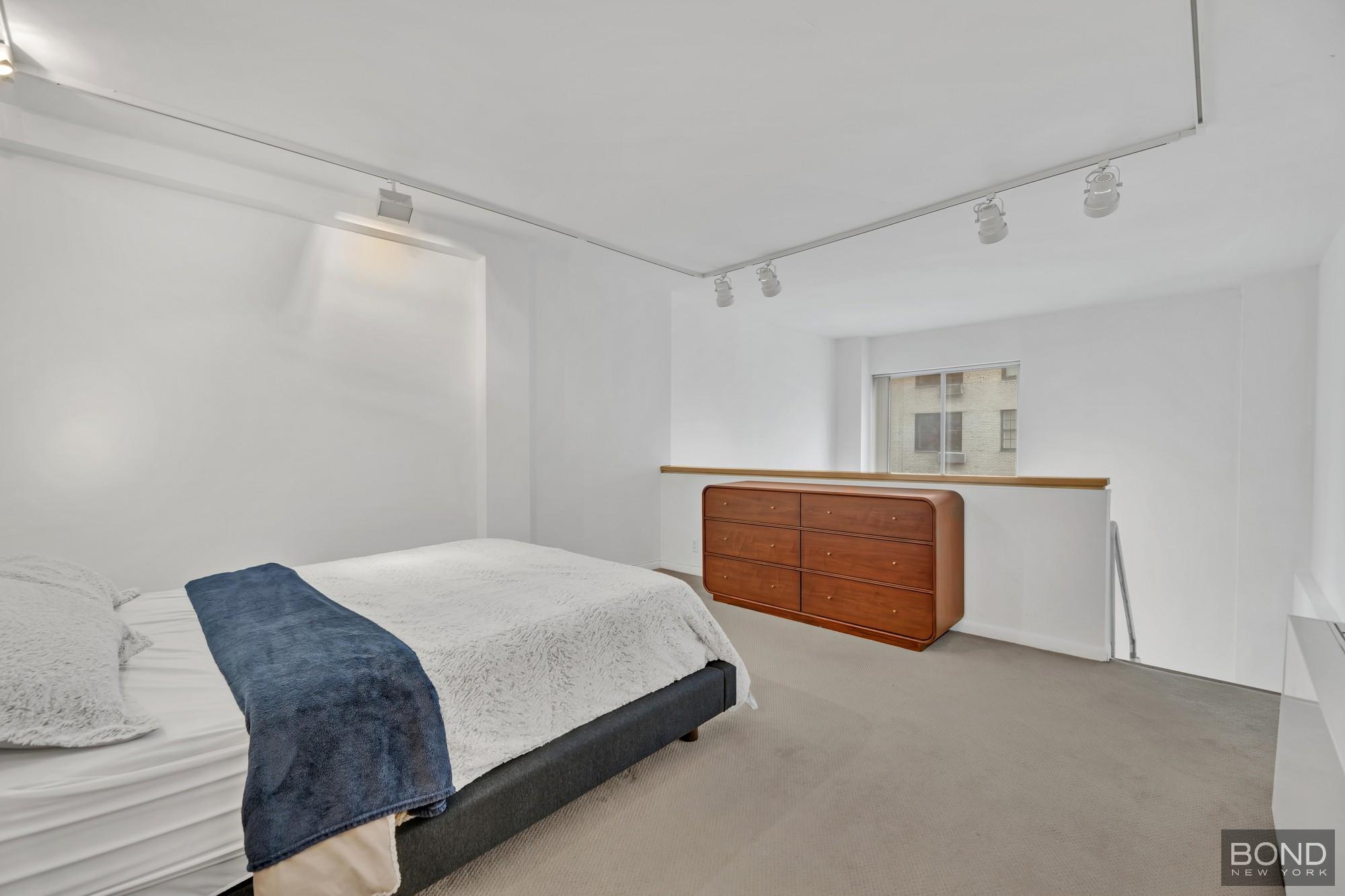32 East 76th Street, Unit 502602 Manhattan, NY 10021 - Photo 7 of 8 a bedroom with a bed and a night stand