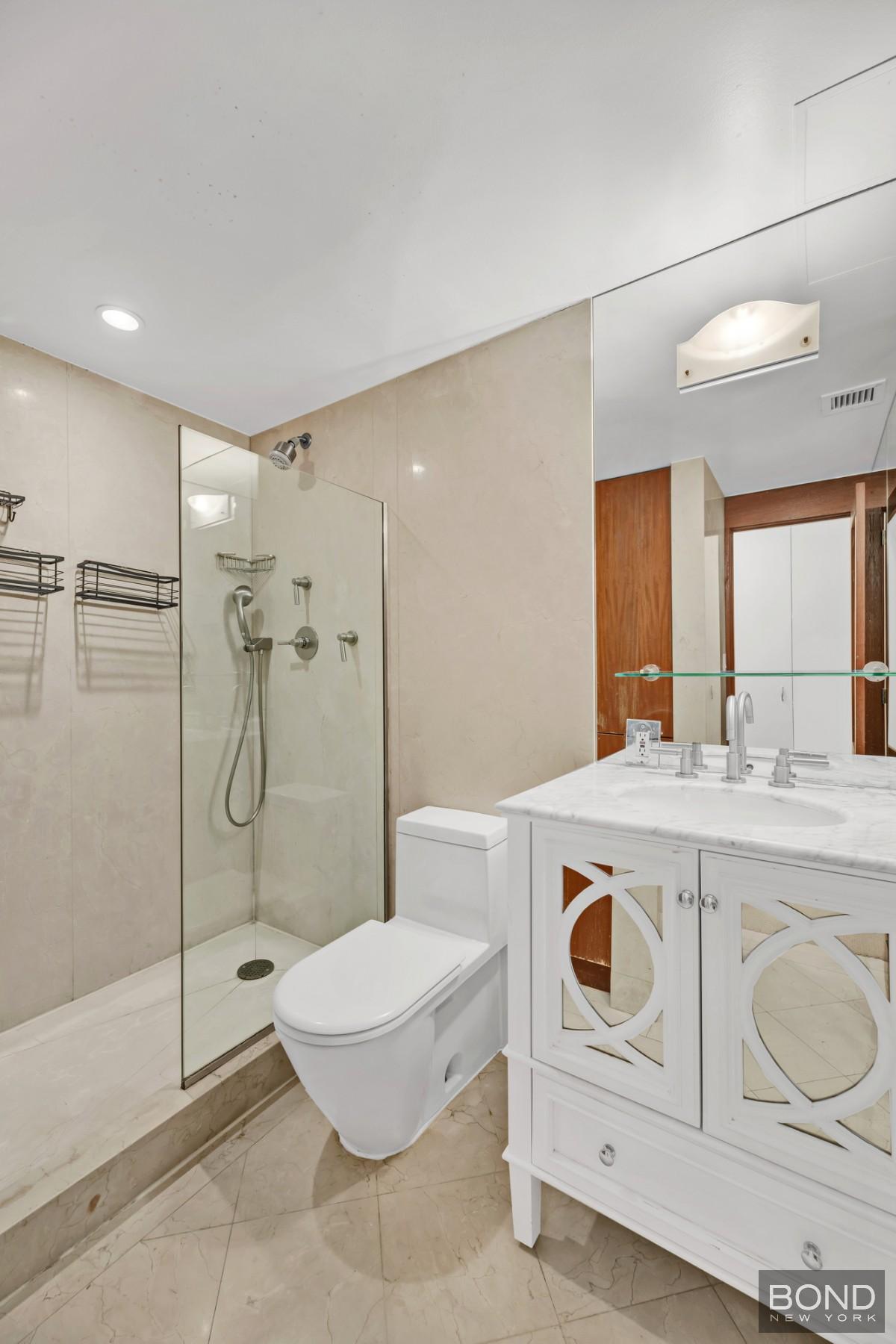 32 East 76th Street, Unit 502602 Manhattan, NY 10021 - Photo 8 of 8 a bathroom with a sink a toilet and shower