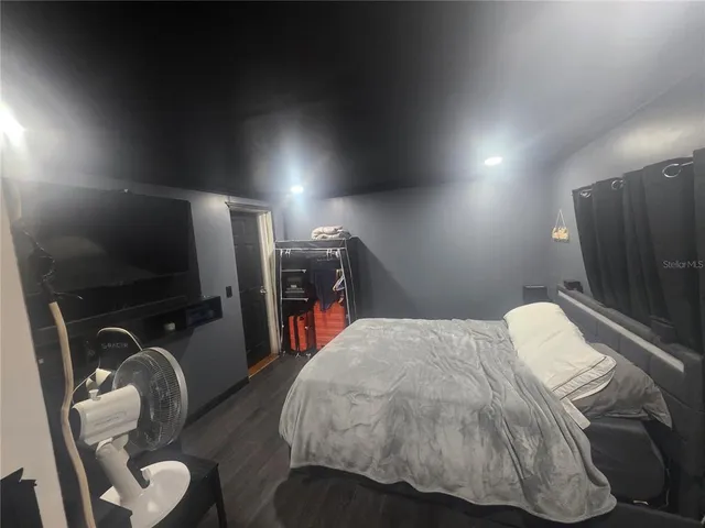 a bedroom with a bed and a flat screen tv