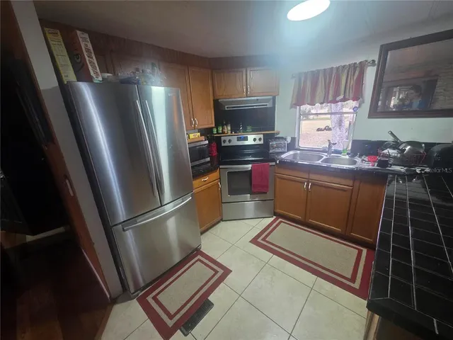 a kitchen with refrigerator a stove a sink and a window
