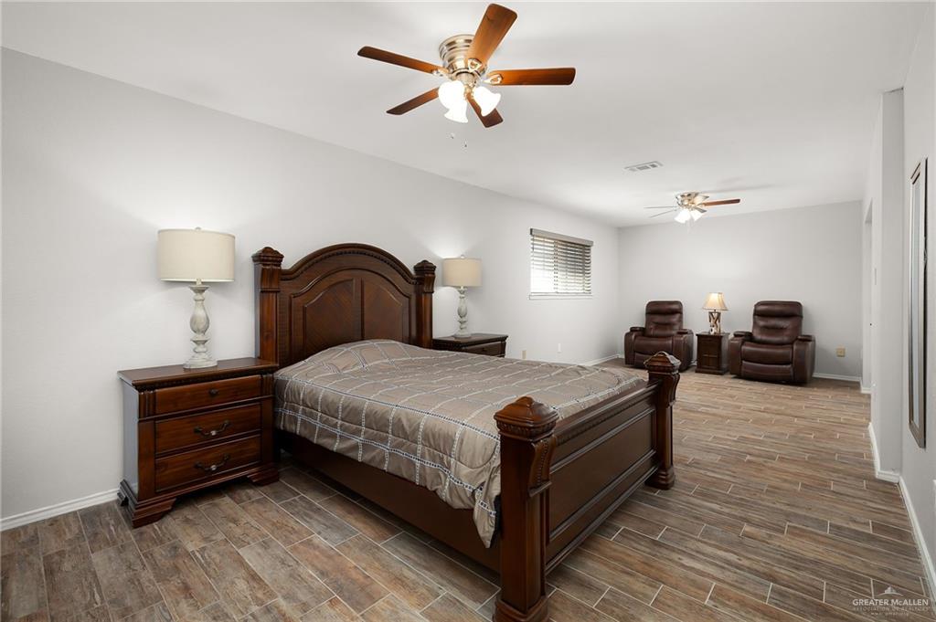 1815 Wilson Street Mission, TX 78572 - Photo 11 of 16 a bedroom with bed and a chandelier