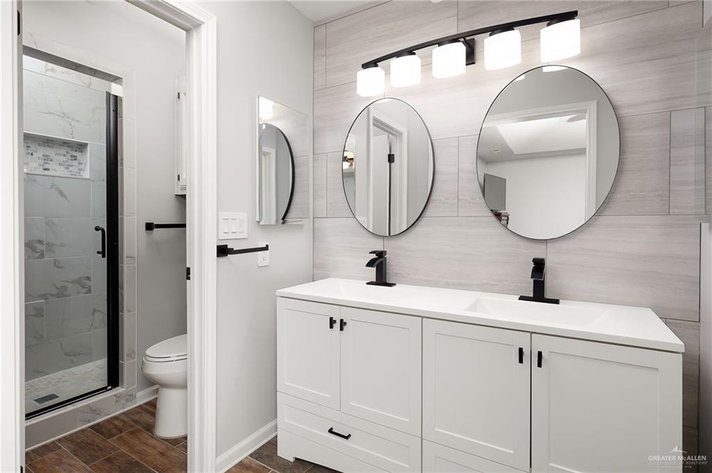 1815 Wilson Street Mission, TX 78572 - Photo 10 of 16 a bathroom with double vanity a toilet a sink and mirror