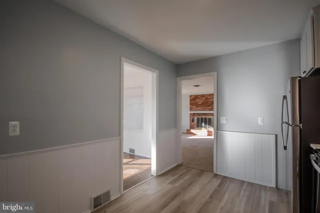 an empty room with wooden floor closet and windows