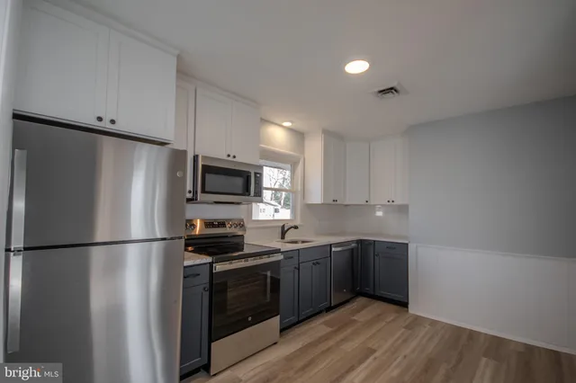 a kitchen with stainless steel appliances a refrigerator sink and cabinets