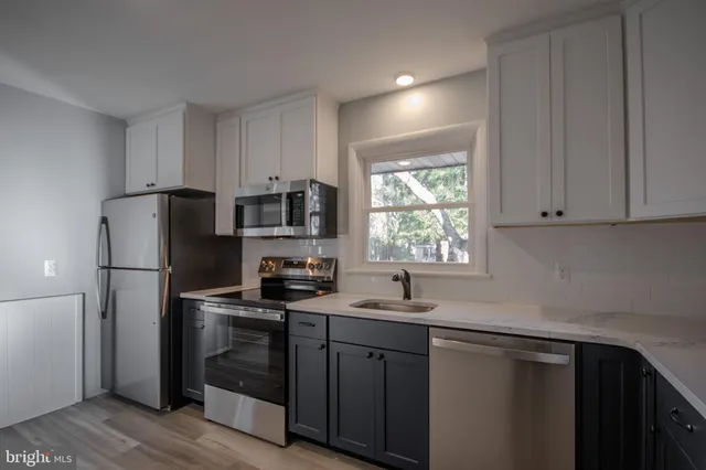 a kitchen with stainless steel appliances a refrigerator sink and microwave