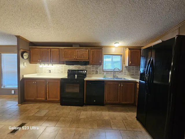 a kitchen with a refrigerator and a stove top oven