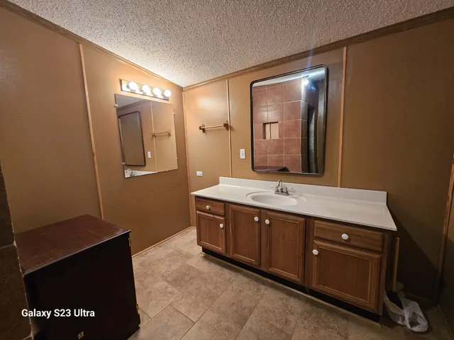 a spacious bathroom with a granite countertop sink and mirror