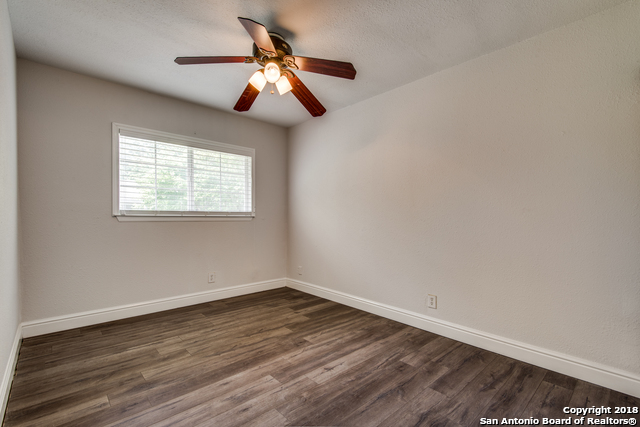 4838 Aspen Wood Kirby, TX 78219 - Photo 2 of 11 an empty room with wooden floor fan and windows