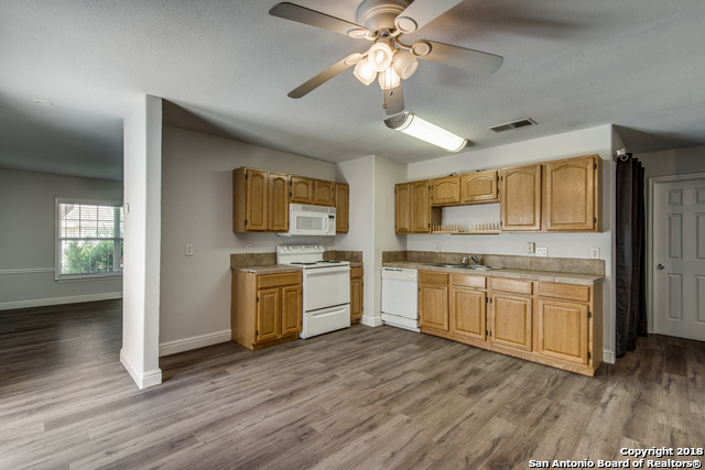 4838 Aspen Wood Kirby, TX 78219 - Photo 6 of 11 a kitchen with a white cabinets and wooden floor