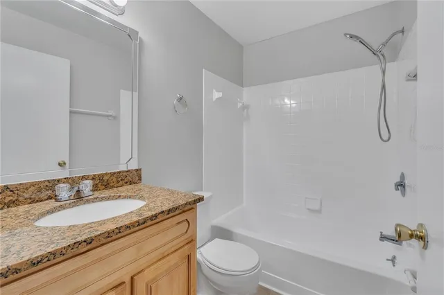a bathroom with a granite countertop sink a mirror and a shower