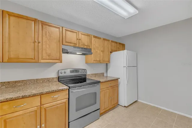 a kitchen with a stove top oven cabinets and a refrigerator