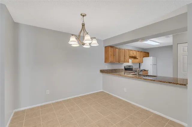 a view of a kitchen with a sink and chandelier
