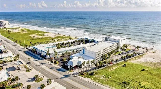 a view of swimming pool with lawn chairs and wooden fence