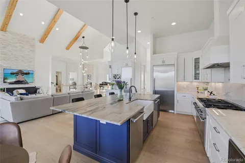 a kitchen with granite countertop a sink stove and refrigerator