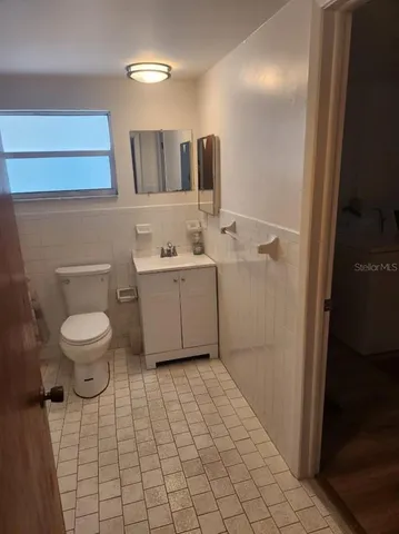 a bathroom with a toilet sink and mirror