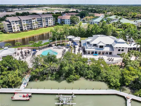 an aerial view of ocean and residential houses with outdoor space