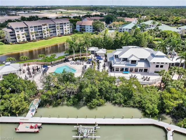 an aerial view of ocean and residential houses with outdoor space