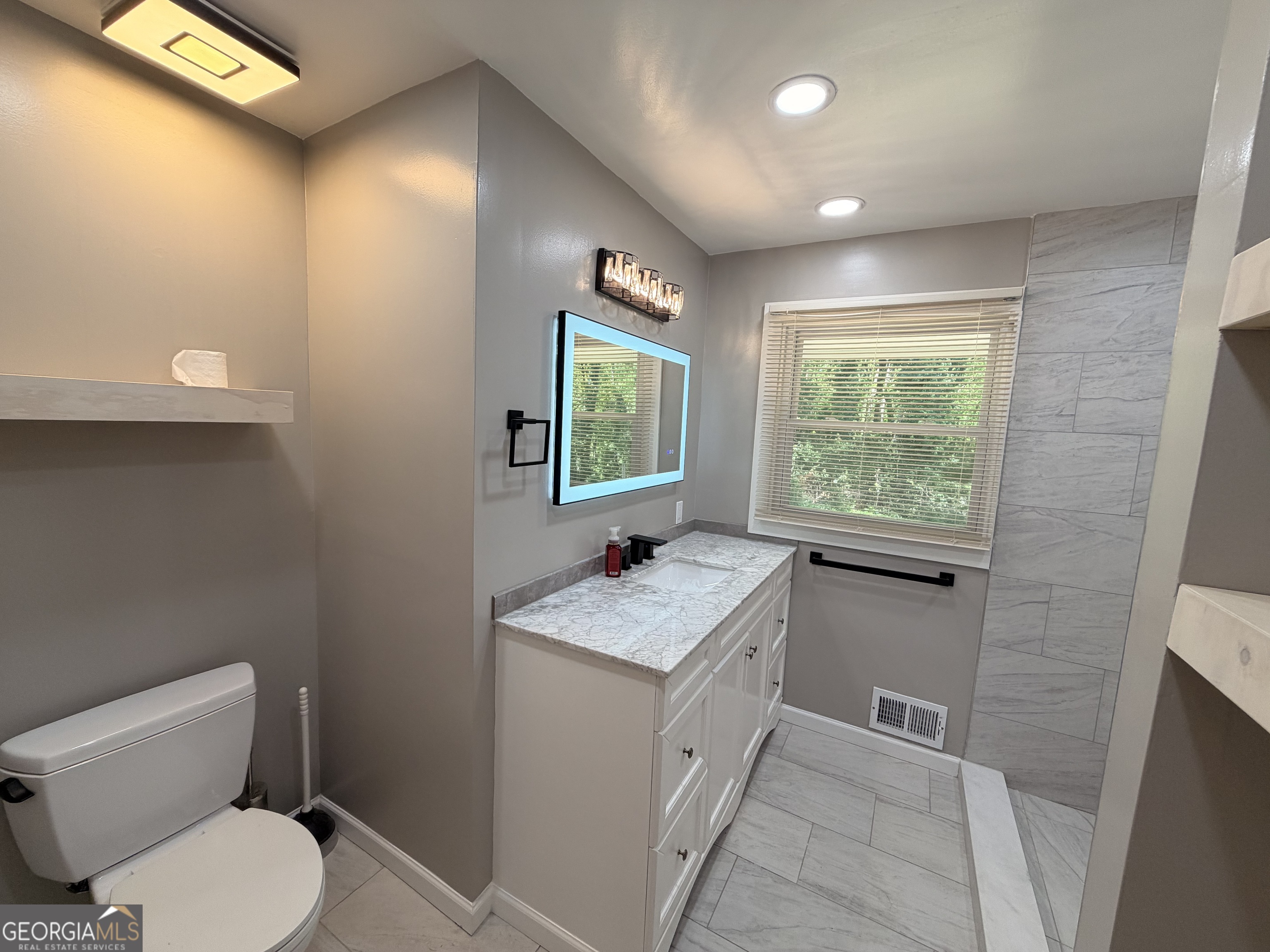 1734 Cahoon Street Southwest Atlanta, GA 30310 - Photo 26 of 29 a bathroom with a granite countertop sink toilet and mirror