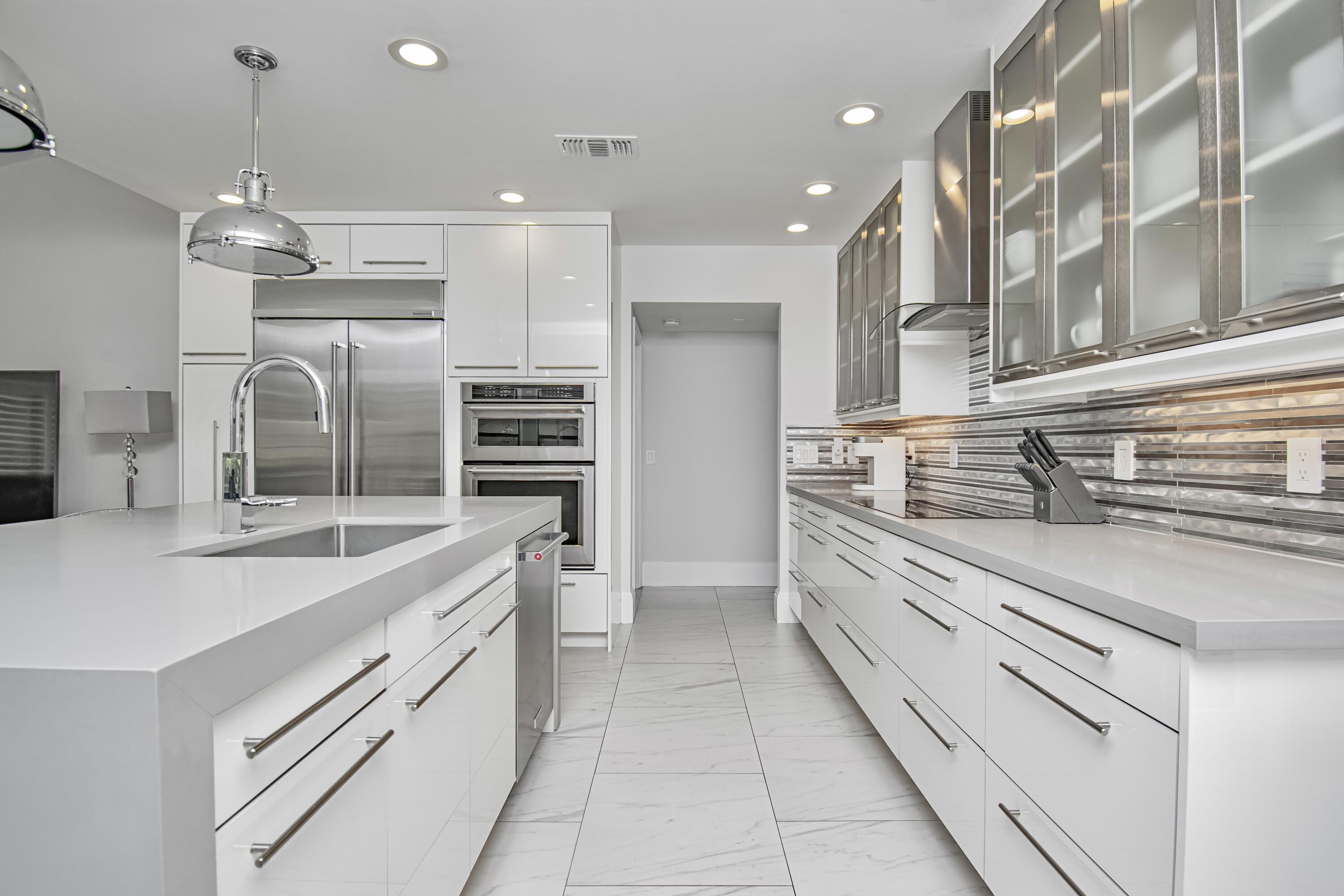 22504 Esplanada Circle Boca Raton, FL 33433 - Photo 12 of 47 a kitchen with stainless steel appliances kitchen island granite countertop a sink and cabinets