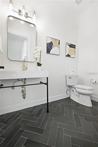 a bathroom with a toilet sink and mirror