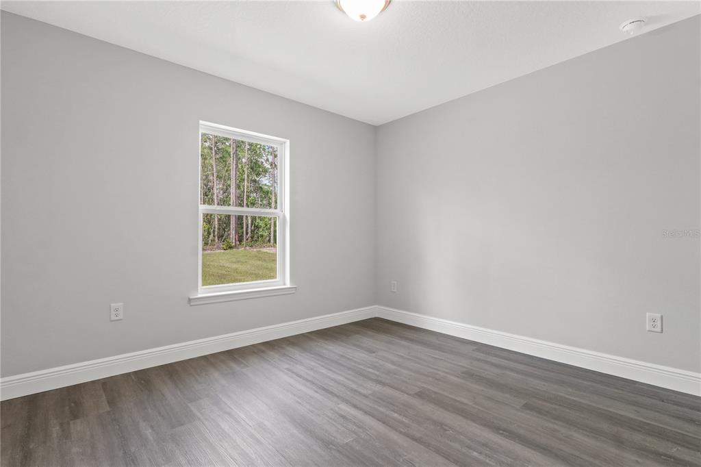 605 Abarth Avenue Sebring, FL 33872 - Photo 13 of 28 an empty room with wooden floor and windows