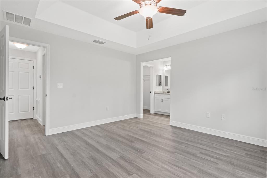 605 Abarth Avenue Sebring, FL 33872 - Photo 21 of 28 an empty room with wooden floor and windows
