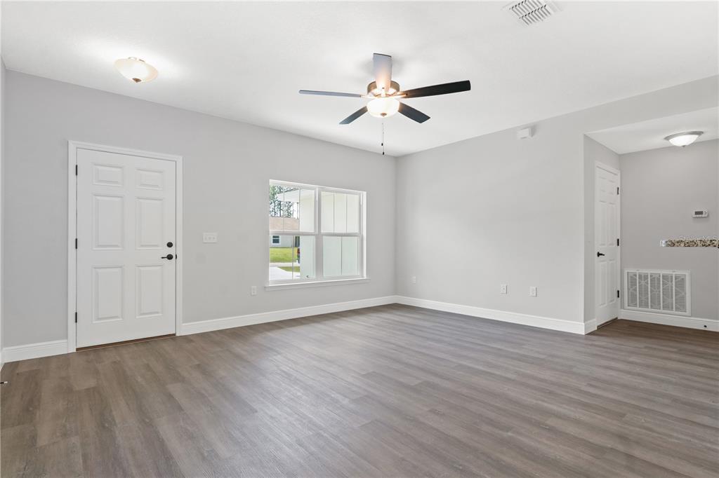 605 Abarth Avenue Sebring, FL 33872 - Photo 24 of 28 a view of an empty room with wooden floor and a window