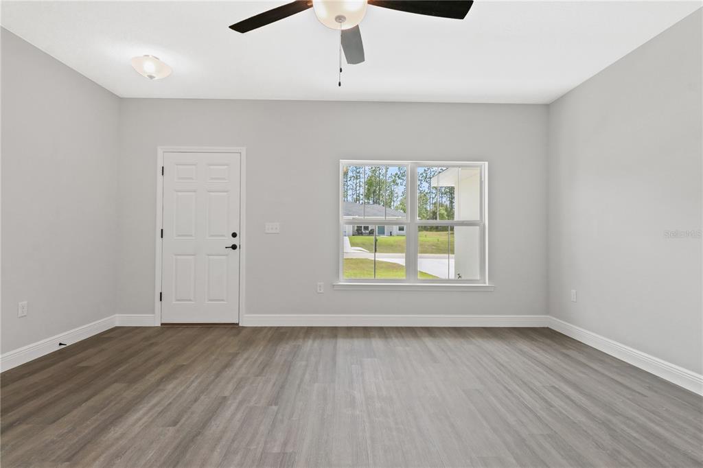 605 Abarth Avenue Sebring, FL 33872 - Photo 25 of 28 an empty room with wooden floor and window