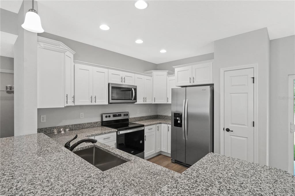 605 Abarth Avenue Sebring, FL 33872 - Photo 28 of 28 a kitchen with stainless steel appliances granite countertop a refrigerator a sink a stove a microwave and island
