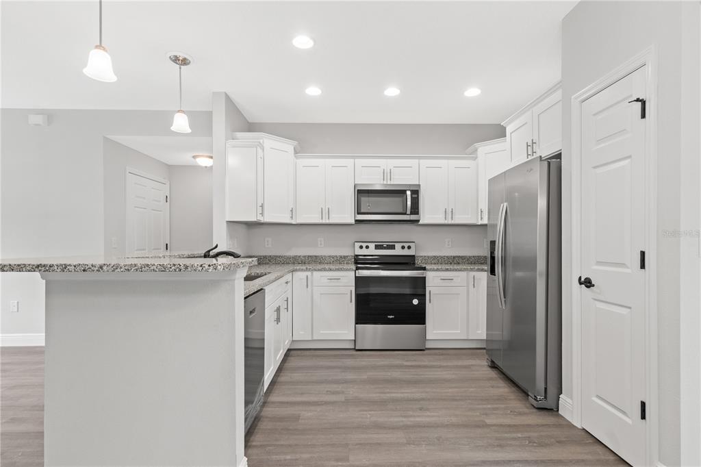605 Abarth Avenue Sebring, FL 33872 - Photo 5 of 28 a kitchen with a refrigerator a sink and a stove top oven