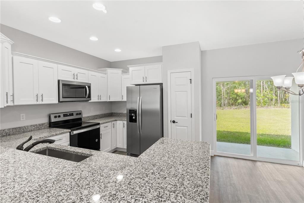 605 Abarth Avenue Sebring, FL 33872 - Photo 7 of 28 a kitchen with stainless steel appliances granite countertop a refrigerator a stove top oven a sink and dishwasher