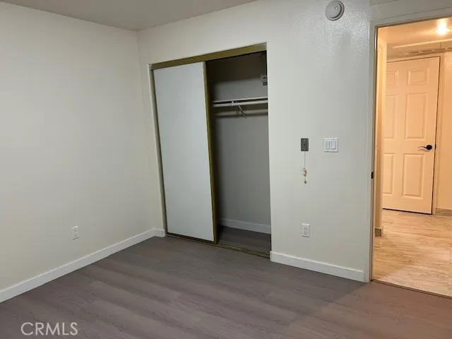 an empty room with wooden floor and closet