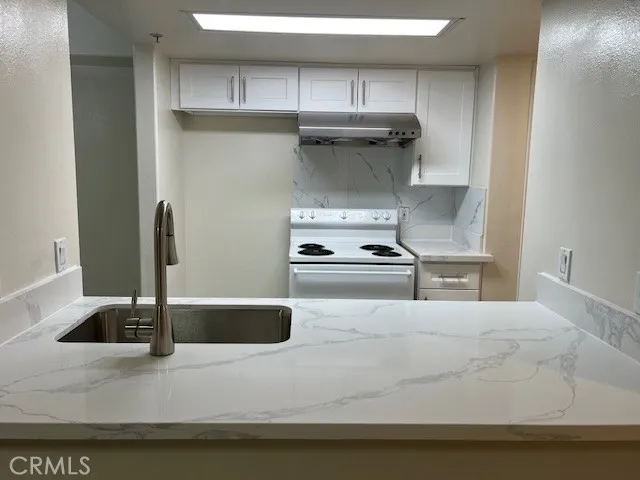 a kitchen with a sink and white cabinets