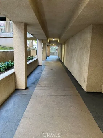 a view of a hallway with wooden floor and windows