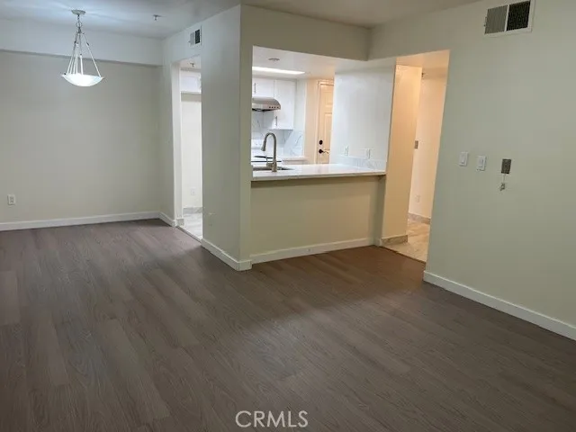 a view of a kitchen with wooden floor and a sink