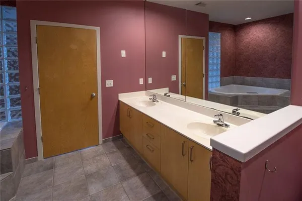 an empty room with wooden floor chandelier and windows