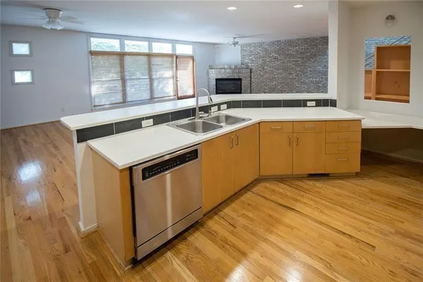 a kitchen with stainless steel appliances granite countertop a refrigerator a stove top oven a sink and dishwasher