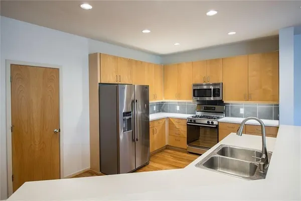 a view of kitchen and hall with wooden floor