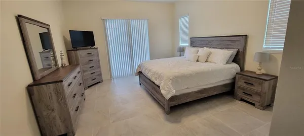 a bedroom with a bed flat screen tv and a large mirror