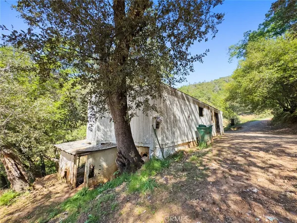 a view of a house with a large tree and wooden fence
