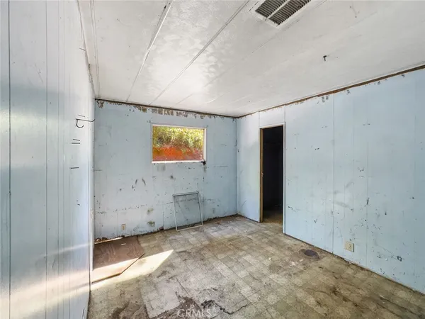 a view of a bedroom with a bed and a window
