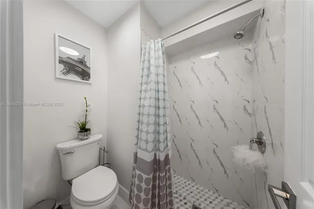 a white toilet sitting next to a bathroom sink