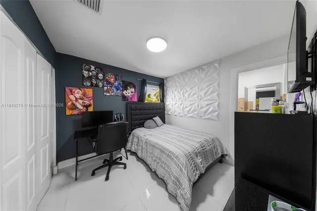 a bedroom with a bed and a flat screen tv