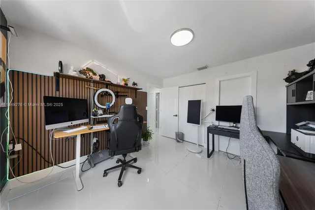 a view of a workspace with furniture and a flat screen tv