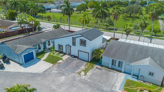 an aerial view of a house with swimming pool next to a big yard