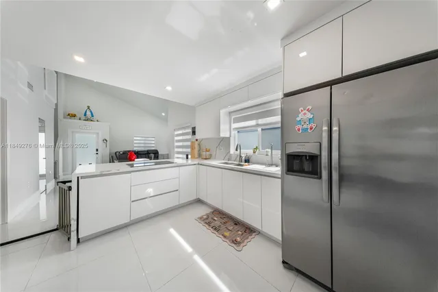 a kitchen with a refrigerator and white cabinets
