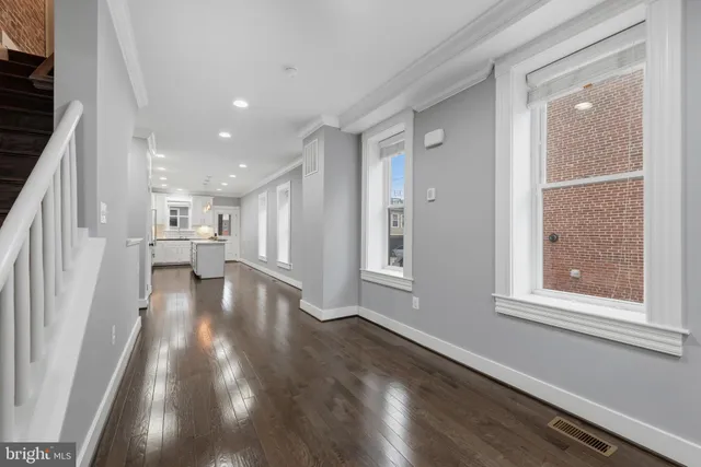 a view of empty room with wooden floor and windows