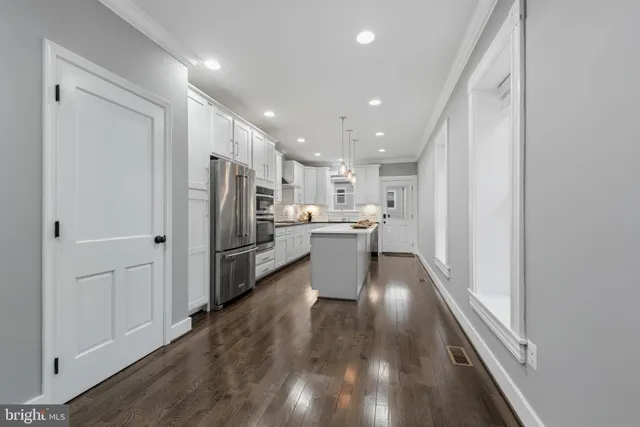 a kitchen with a refrigerator and white cabinets