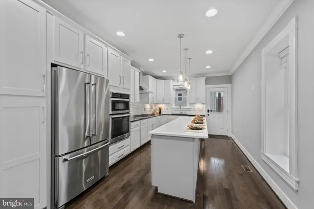 a kitchen with stainless steel appliances a refrigerator and a stove top oven